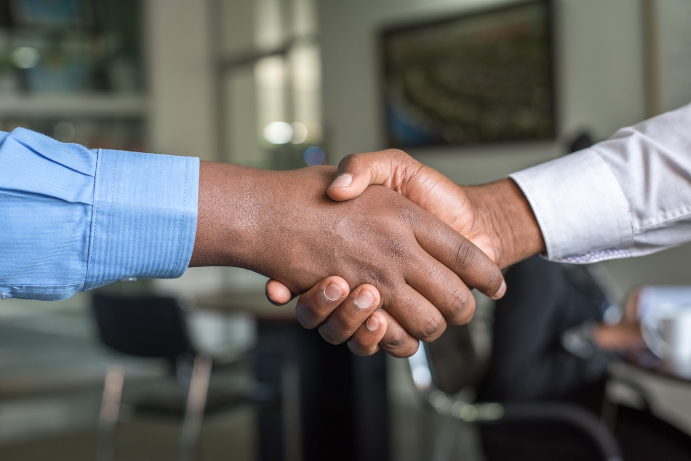 Client and legal translation specialist shaking hands over legal documents